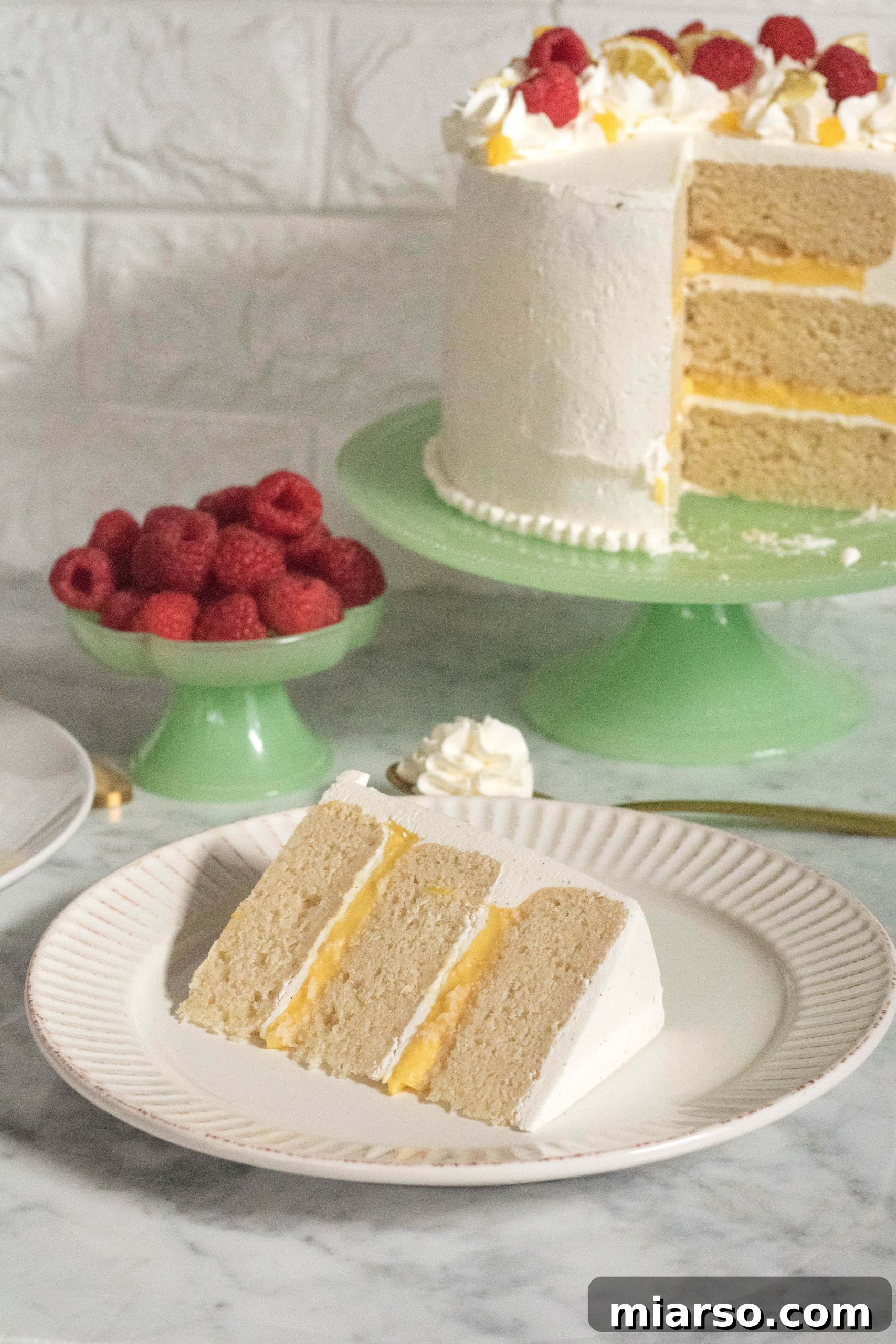 Close-up of a slice of Layered Vanilla cake with lemon curd and Italian vanilla bean buttercream, showing layers