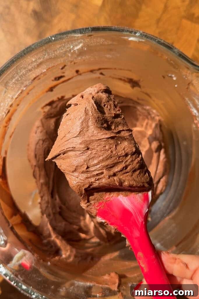 Smooth and fluffy chocolate buttercream in a bowl, ready for frosting.