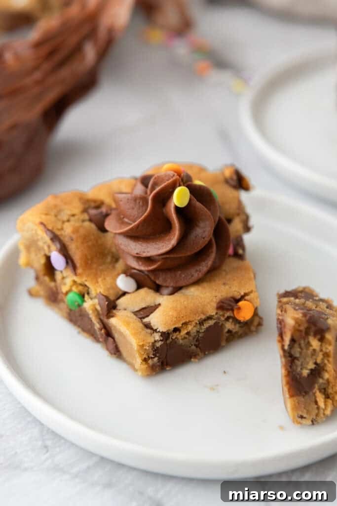 The Ultimate Homemade Chocolate Chip Cookie Cake 2 Chocolate Chip Cookie Cake Recipe on a plate, adorned with frosting