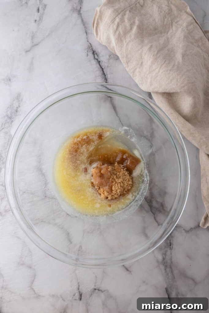 The Ultimate Homemade Chocolate Chip Cookie Cake 5 Melted butter and sugars in a bowl