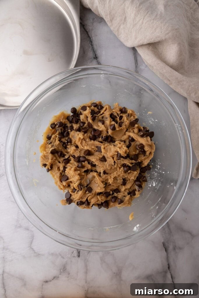 The Ultimate Homemade Chocolate Chip Cookie Cake 9 Dough being pressed into the baking pan