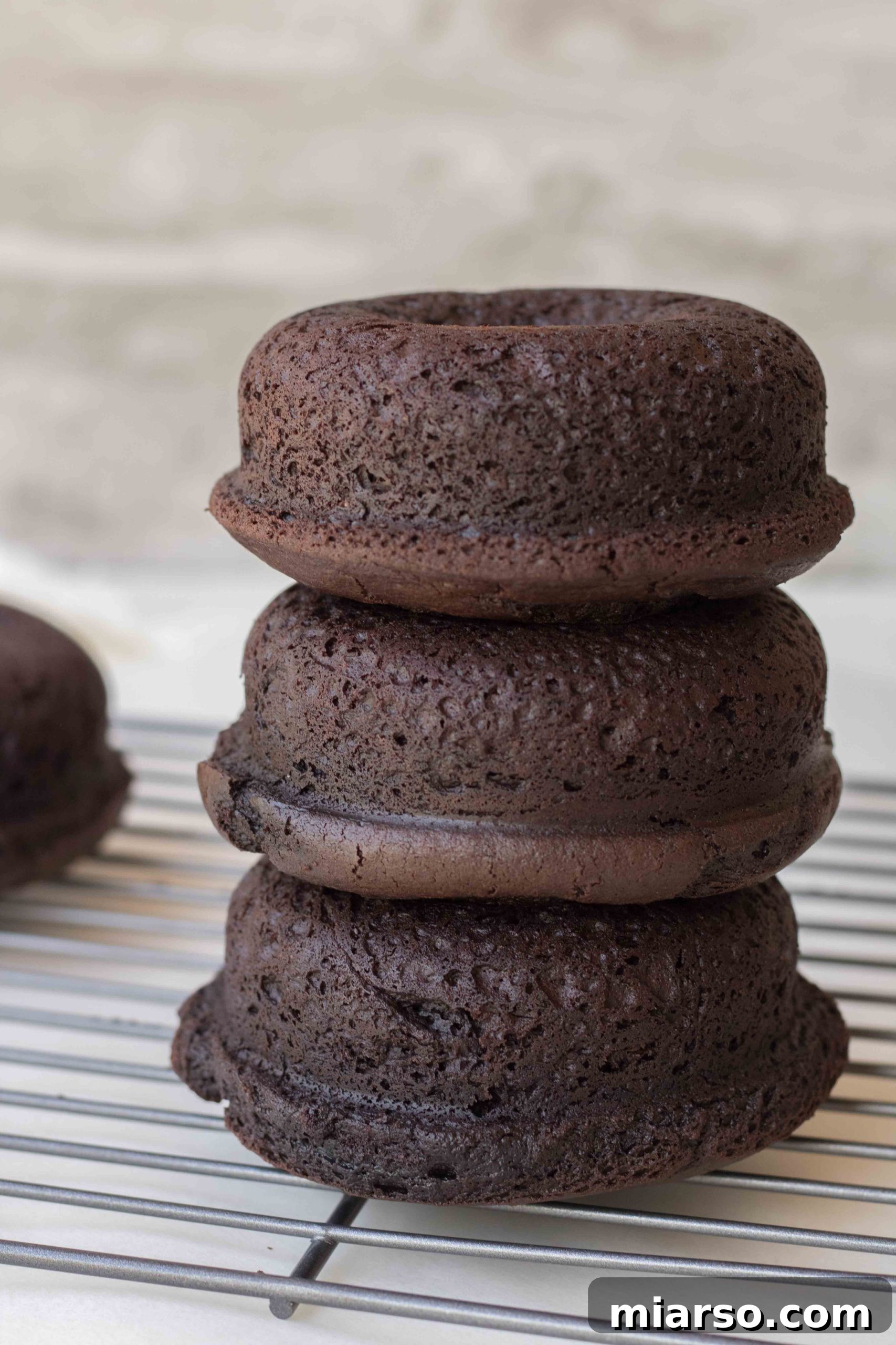 Baked chocolate donuts cooling on a wire rack before glazing