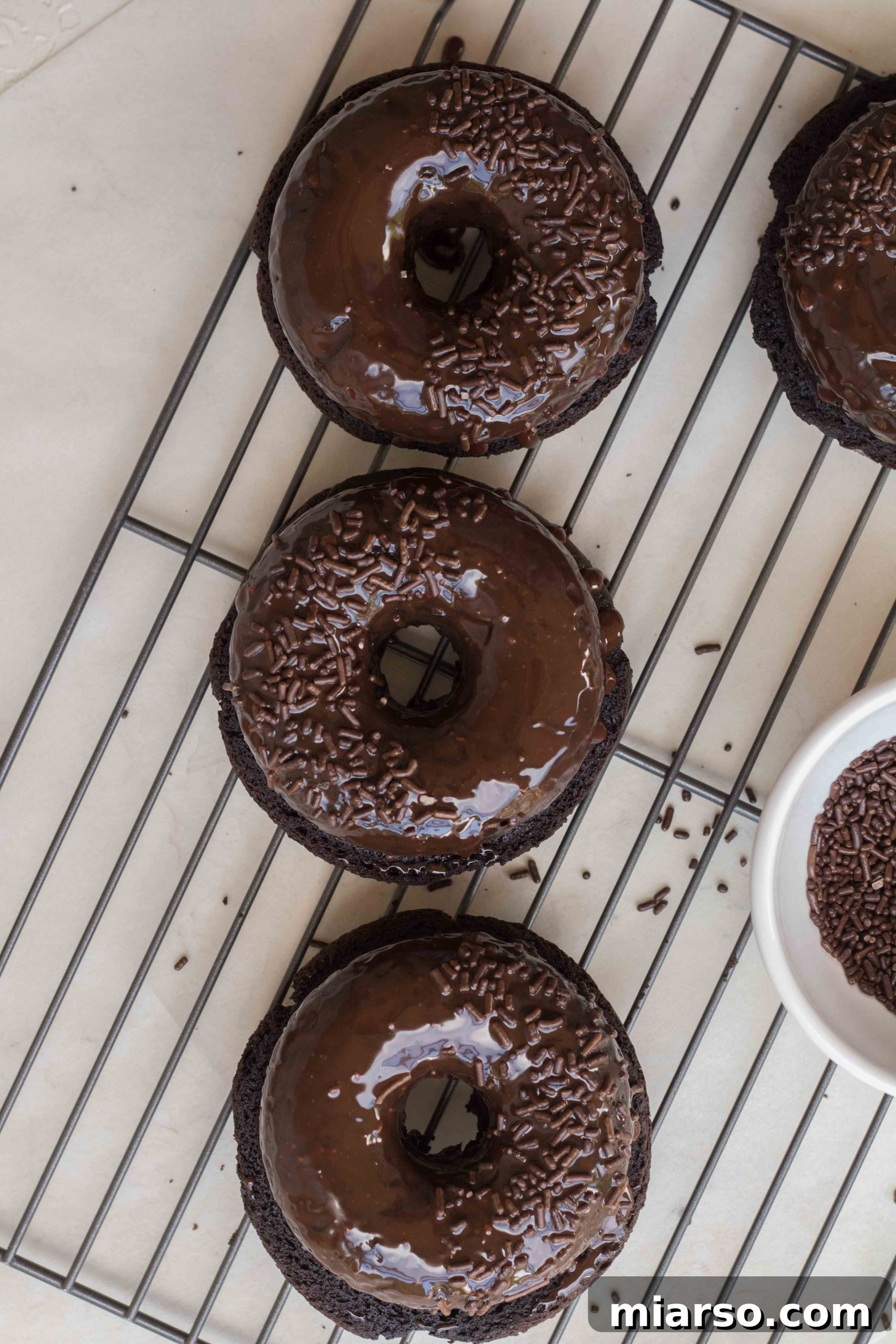 Baked chocolate donuts with chocolate ganache and sprinkles