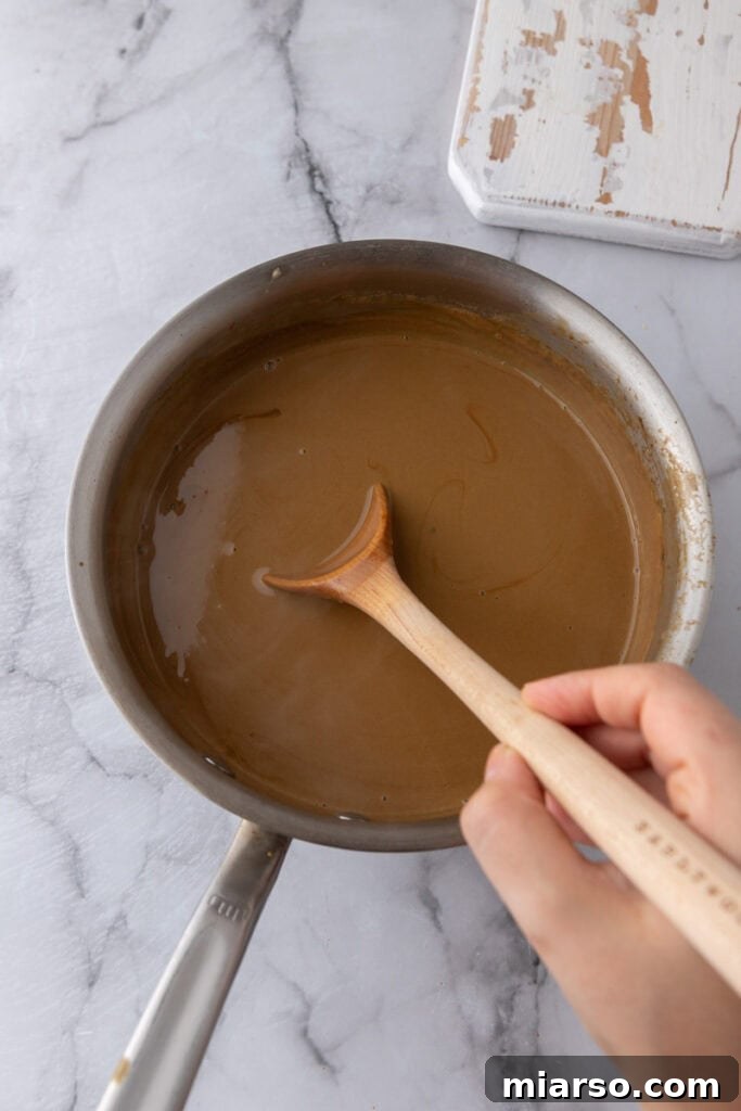 Custard base thickening in a pot with a wooden spoon