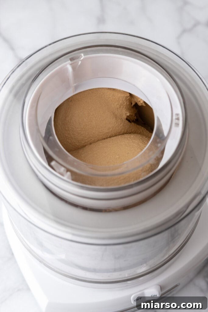 Custard mixture being churned in an electric ice cream machine