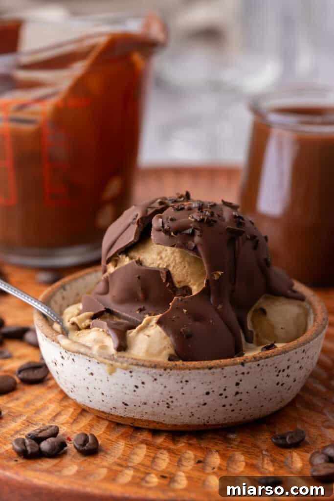 Easy 5-Minute Magic Chocolate Shell for Ice Cream 12 Magic chocolate shell on ice cream with a spoon, ready to be enjoyed.