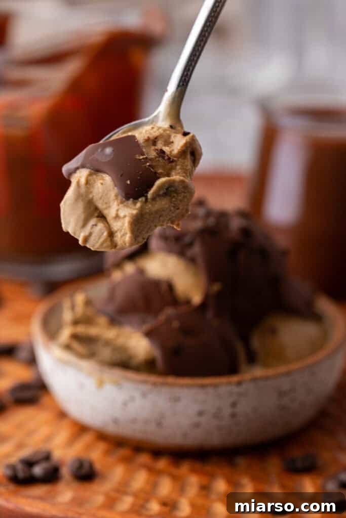 Easy 5-Minute Magic Chocolate Shell for Ice Cream 4 Magic chocolate shell recipe mixture on a spoon, showing its smooth, pourable consistency.