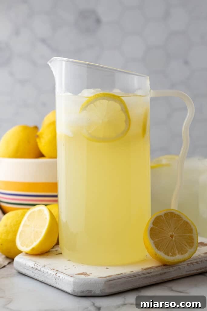 Homemade lemonade in a pitcher with lemon slices and mint for garnish