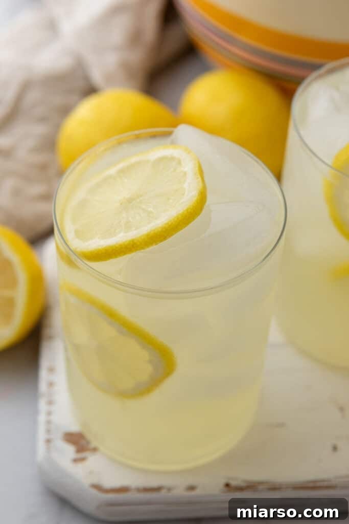 Homemade lemonade poured into a glass with lemon slices