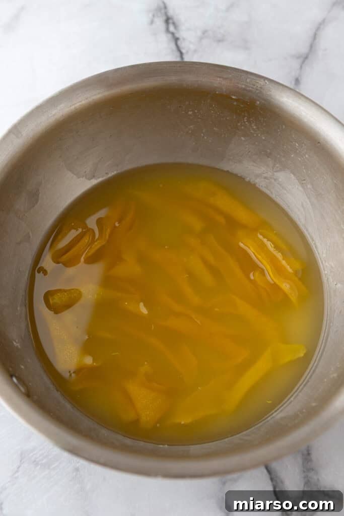 Straining the lemon simple syrup into a pitcher