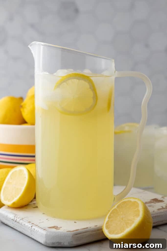 Finished lemonade in a pitcher with ice and lemon slices