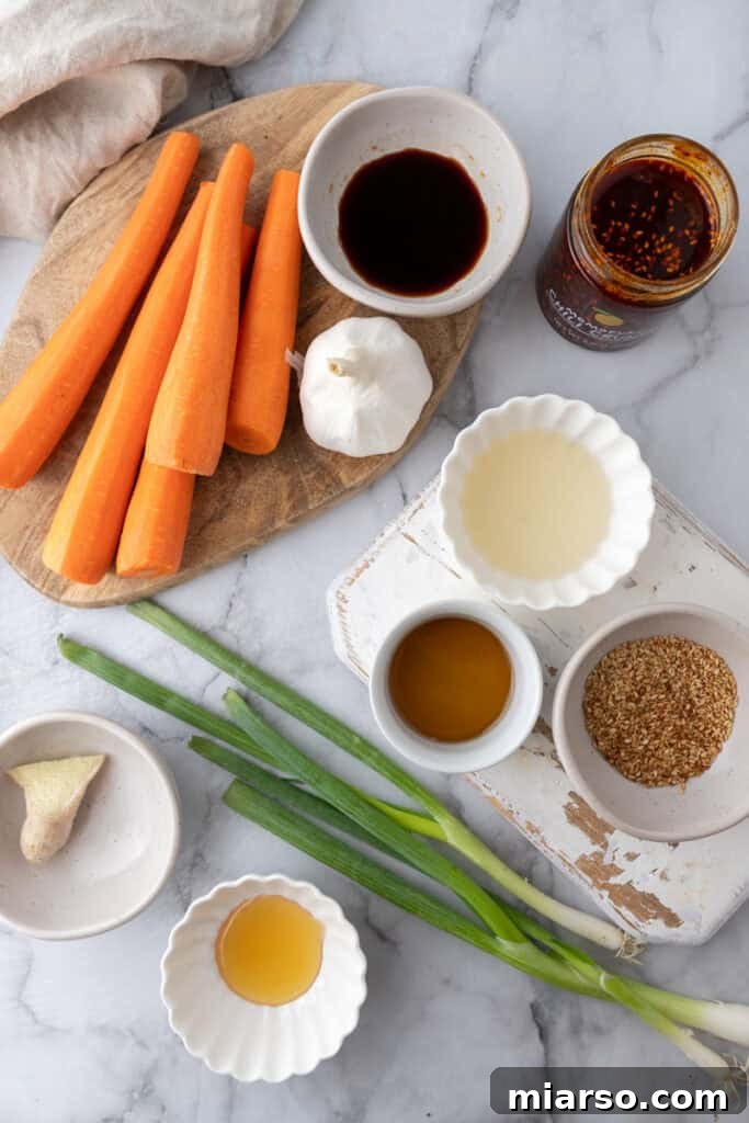 Fresh ingredients for Carrot Ribbon Salad neatly arranged, including vibrant carrots, green onions, sesame seeds, and various dressing components.
