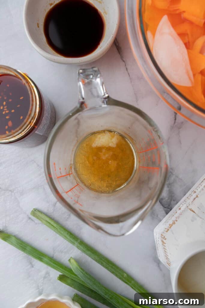Close-up of a spoon mixing dressing ingredients in a small glass bowl.