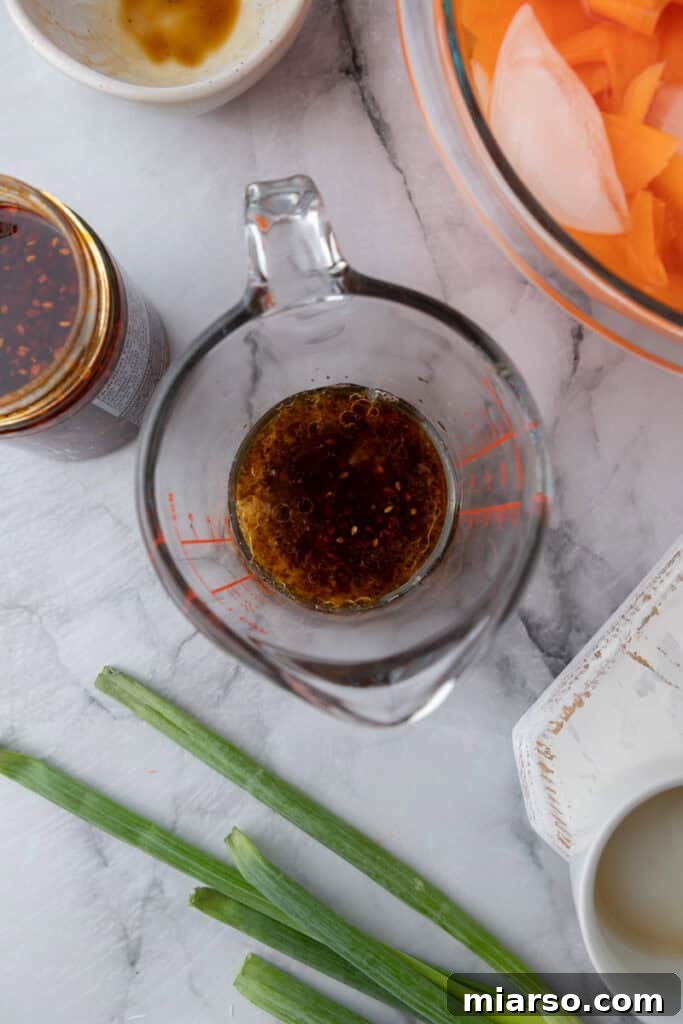 A small bowl containing a vibrant, whisked dressing mixture.
