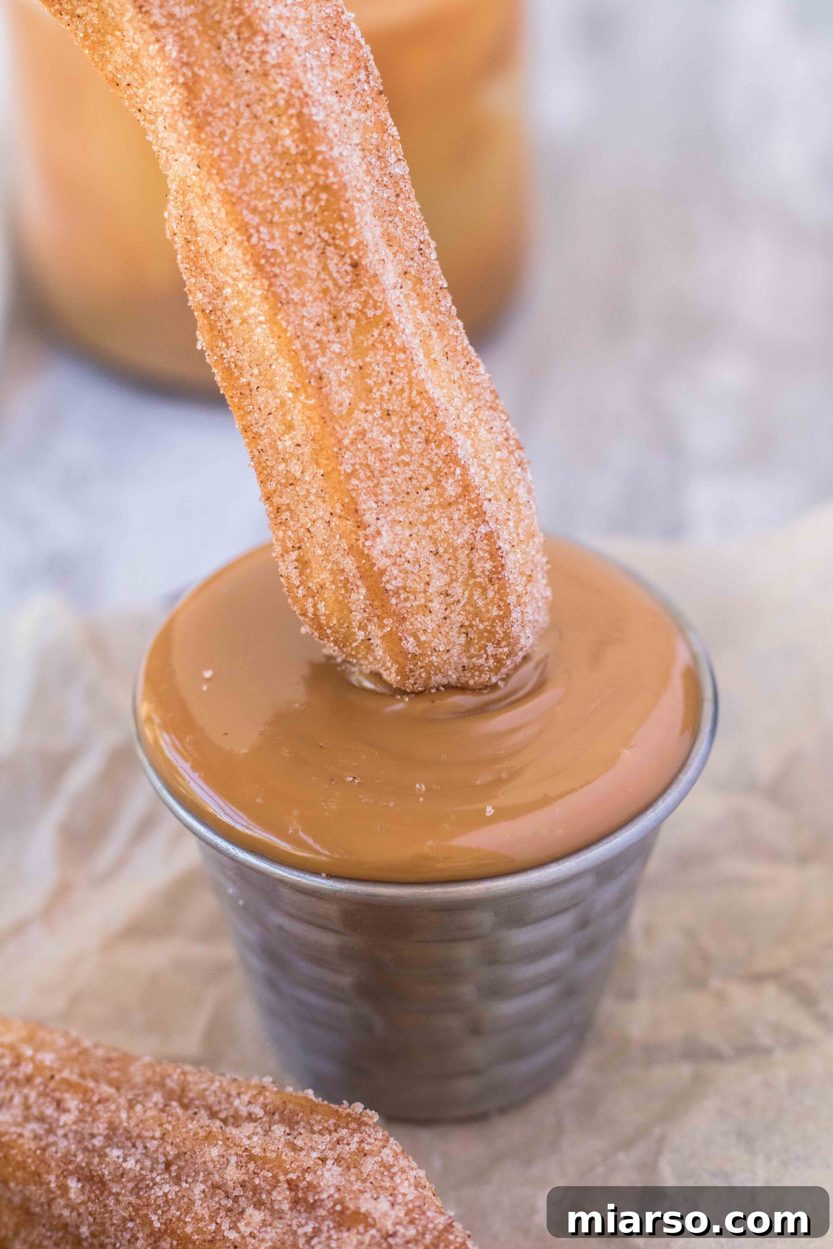 Easy homemade air fryer churros coated in cinnamon sugar, ready to be dipped.