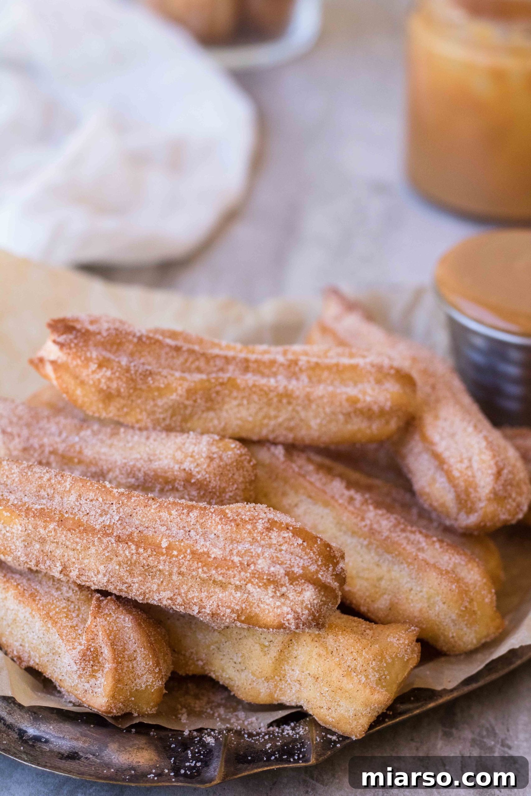 Close up of a churro with defined ridges, showcasing its golden texture before coating.