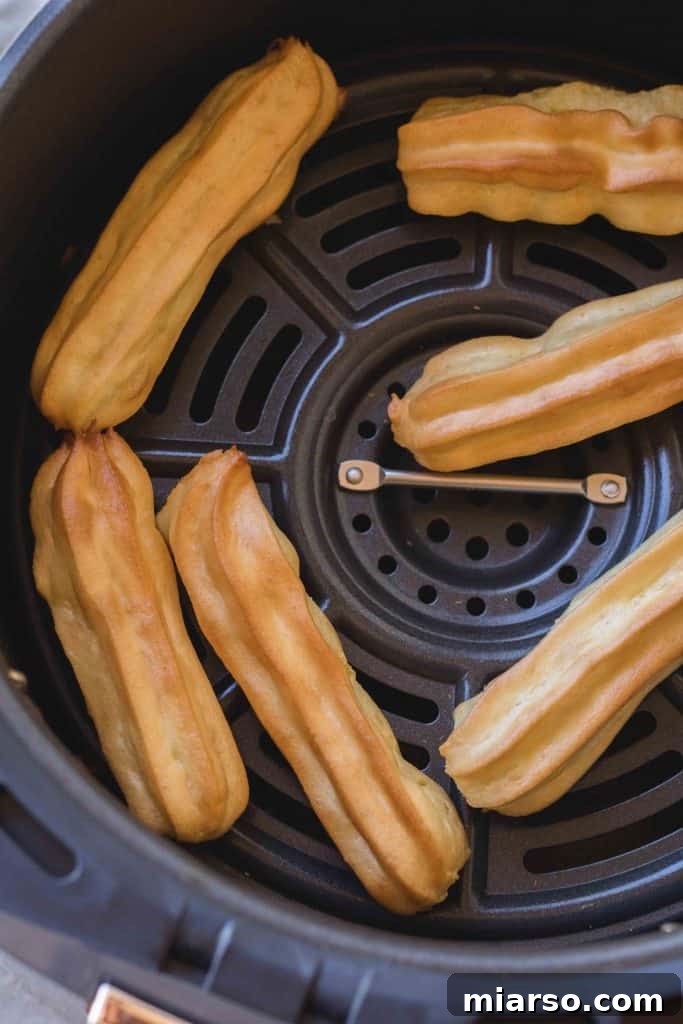 Frozen churro dough being placed into an air fryer basket.