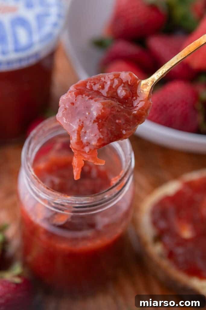 strawberry rhubarb jam recipe in a jar with a spoon