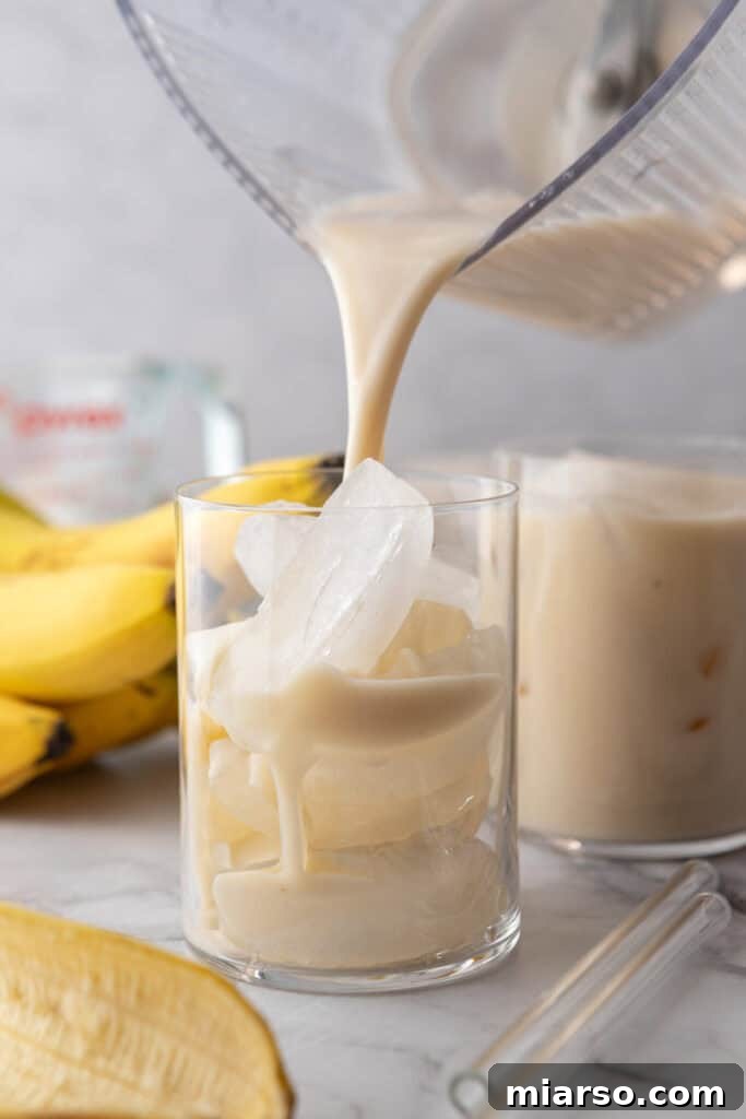 A glass of Korean Banana Milk garnished with a banana slice
