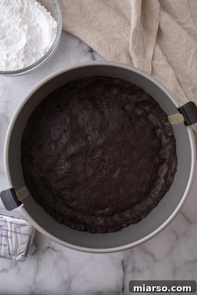 Oreo crust mixture pressed firmly into a springform pan