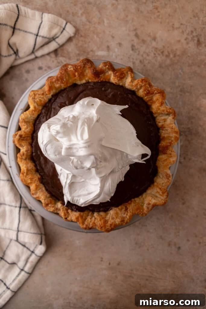 Mastering Chocolate Meringue Pie 16 topping being spread onto filling