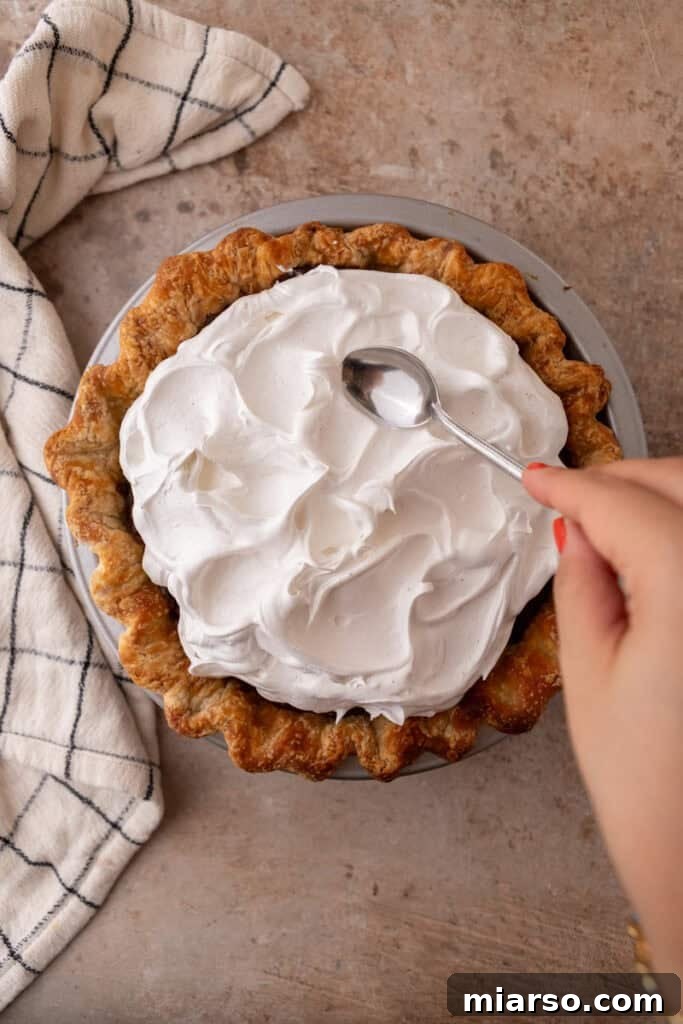 Mastering Chocolate Meringue Pie 17 topping being spread onto filling