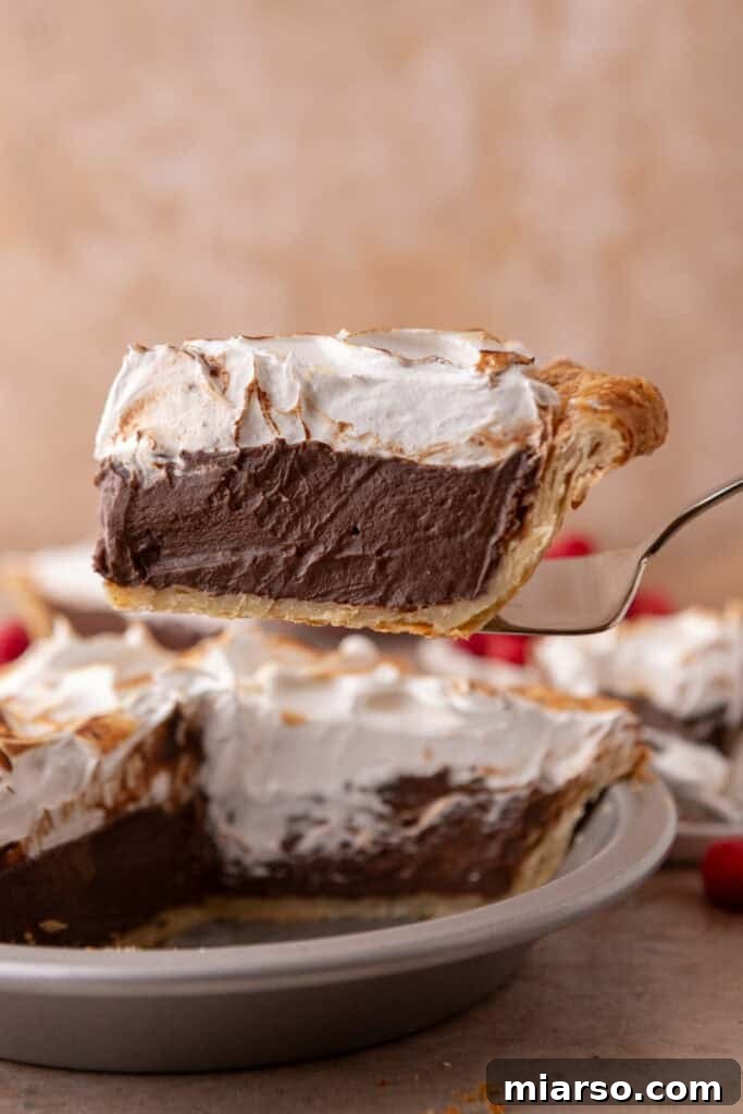 Mastering Chocolate Meringue Pie 21 chocolate meringue pie slice on a serving spatula