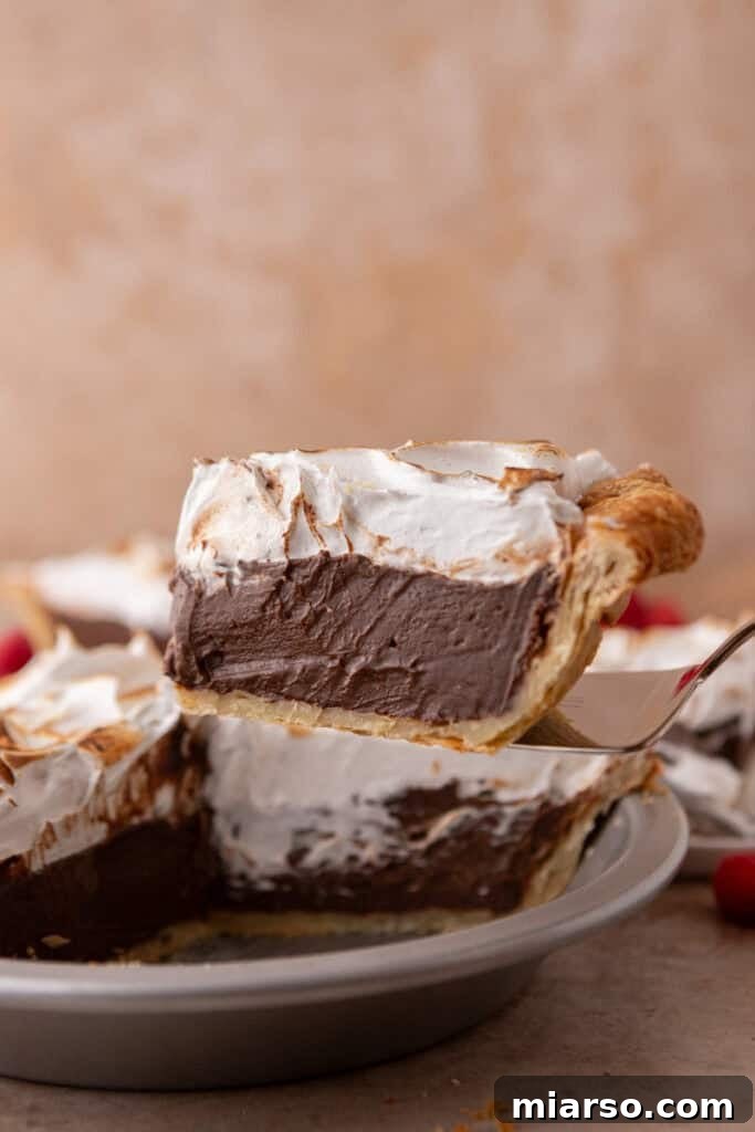 Mastering Chocolate Meringue Pie 23 chocolate meringue pie slice on a serving spatula