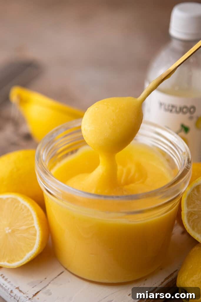 Yuzu Curd Recipe in a jar with a spoon taking a scoop