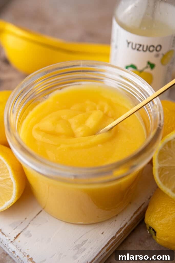 Yuzu Curd Recipe in a jar with a spoon, angled view