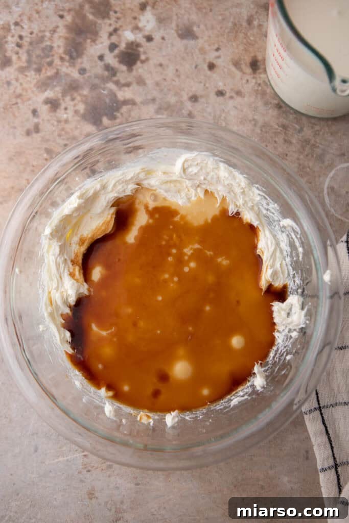 Cream cheese being beaten smooth in a bowl