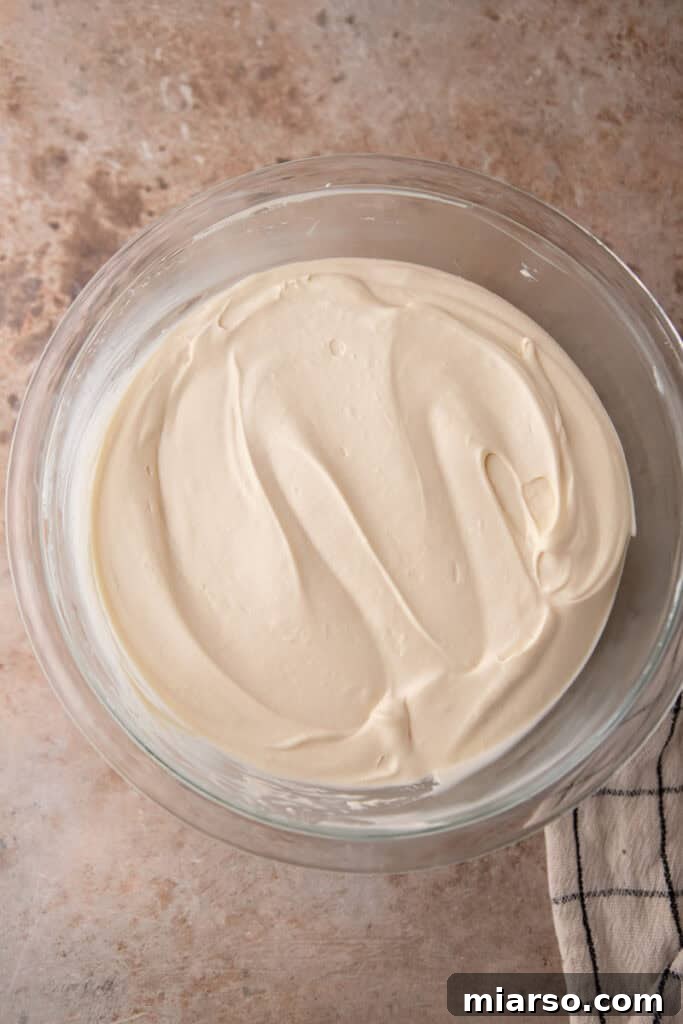 Final whipped cream being gently folded, maintaining airiness