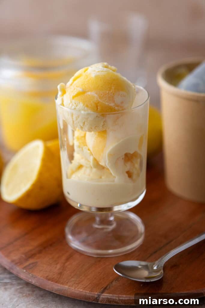 Smooth, creamy homemade lemon ice cream in a clear glass container, ready to be served.