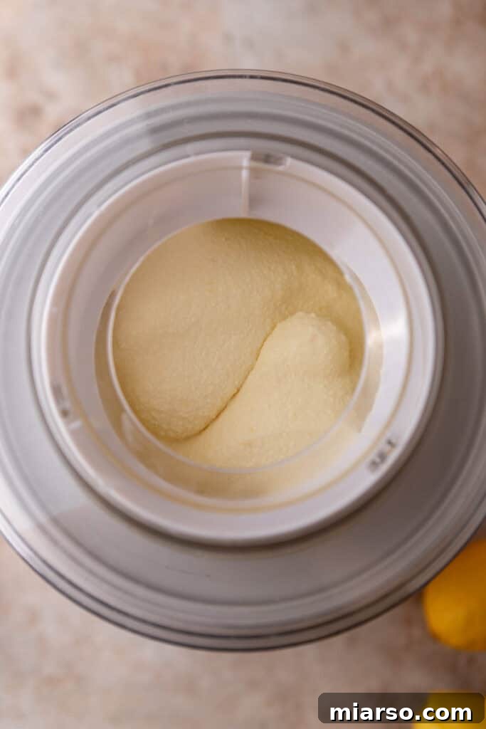 Close-up of lemon ice cream churning in a machine, looking creamy.
