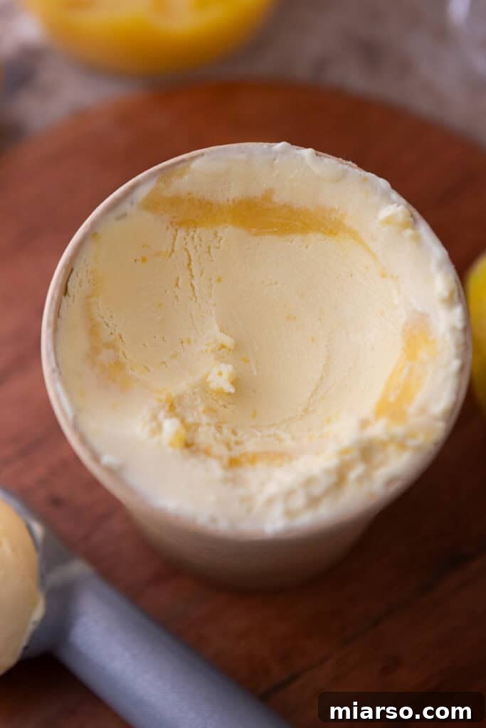 Another view of layering lemon ice cream with lemon curd, showing the creamy texture.