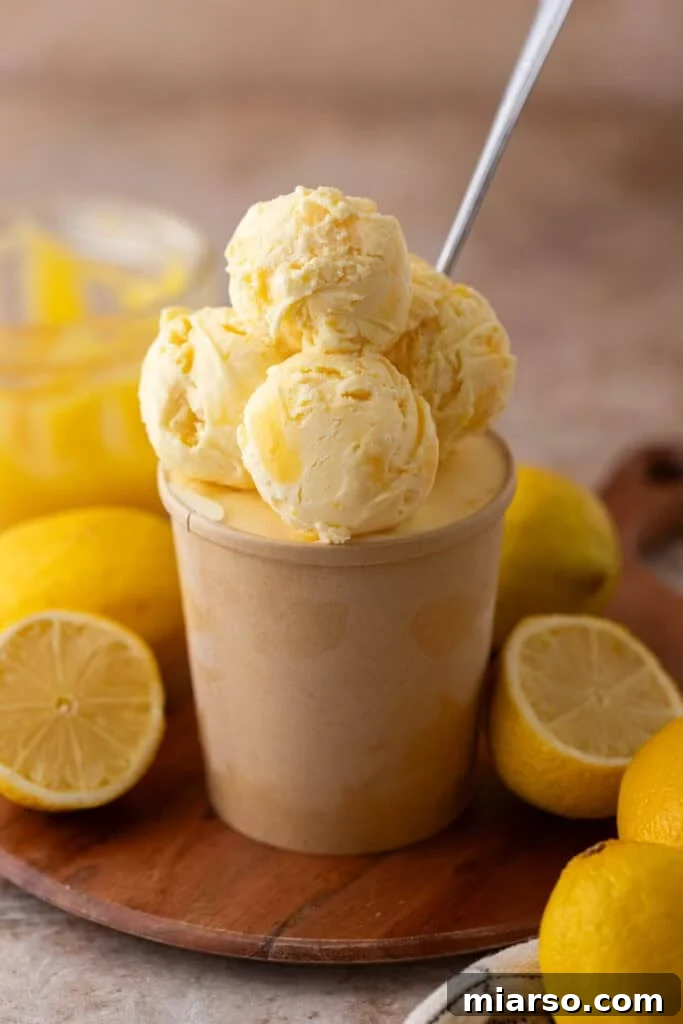Beautifully scooped lemon ice cream with a subtle swirl, presented in a container.