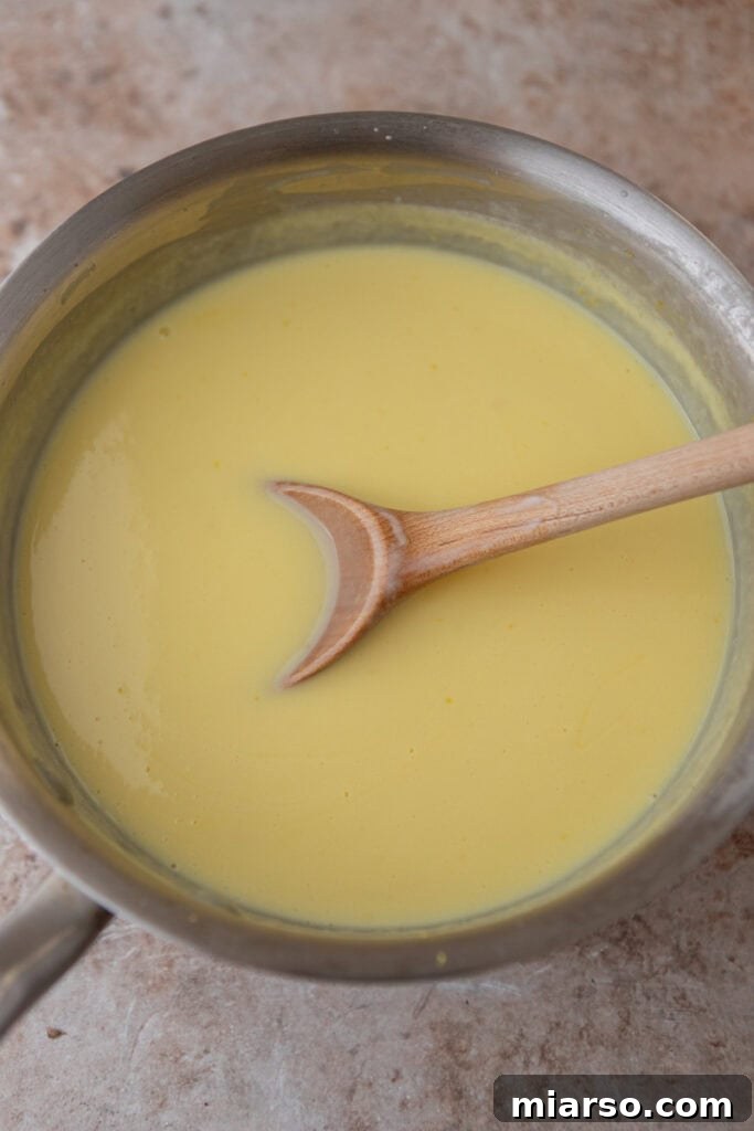 Chilled lemon custard base being poured into an ice cream maker for churning.