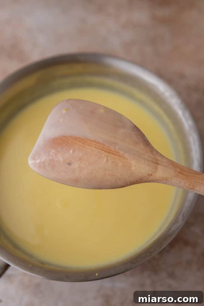 Lemon ice cream churning in an ice cream machine, reaching soft-serve consistency.