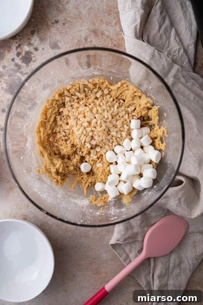 Cookie dough with Rice Krispies and mini marshmallows folded in, showcasing the mix-ins.