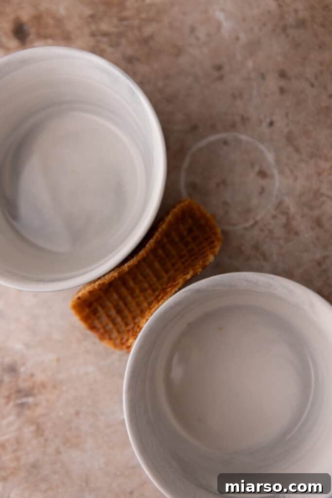 A warmed stroopwafel being carefully folded into a taco shape