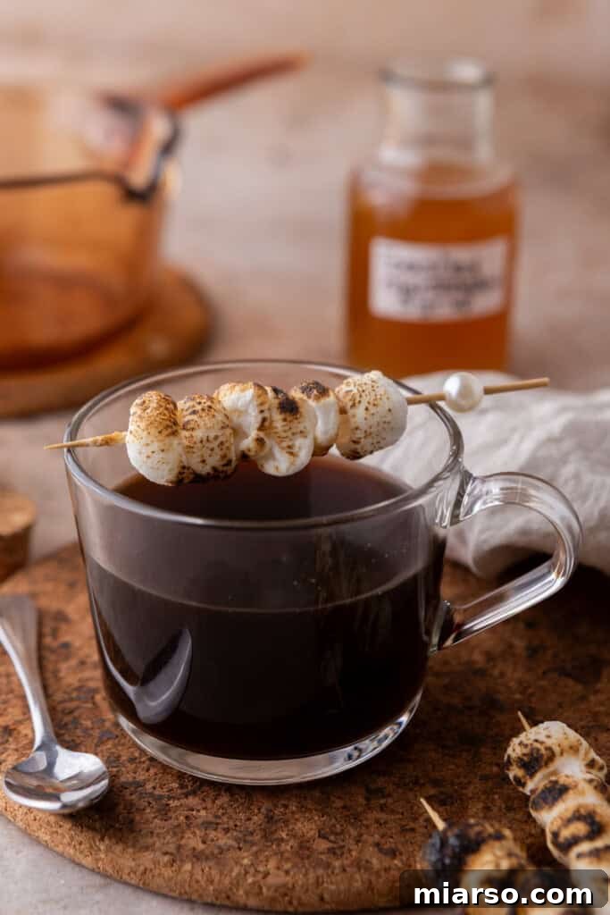 A warm coffee drink topped with perfectly toasted marshmallows, inviting a cozy experience.