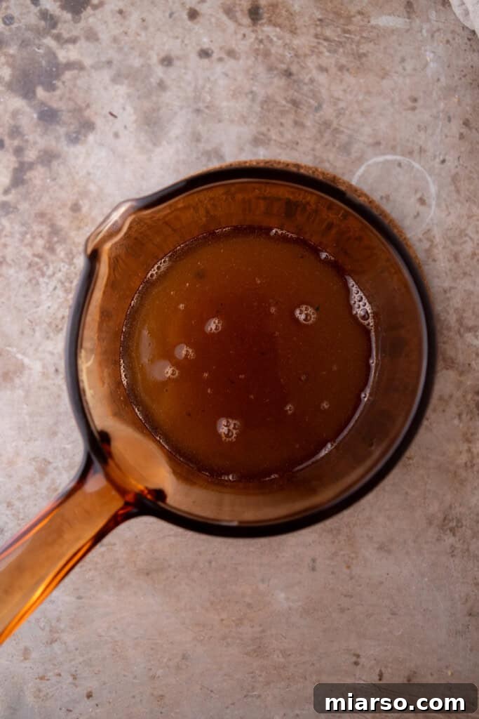 Toasted marshmallows dissolving into the simmering sugar syrup in a pot.
