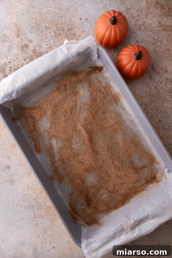 Parchment paper in a baking pan, lightly greased and sprinkled with cinnamon sugar