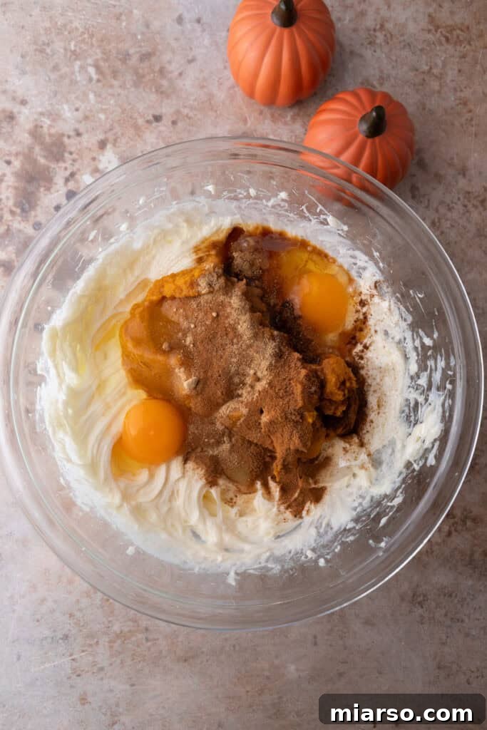 Eggs being added to the cream cheese mixture