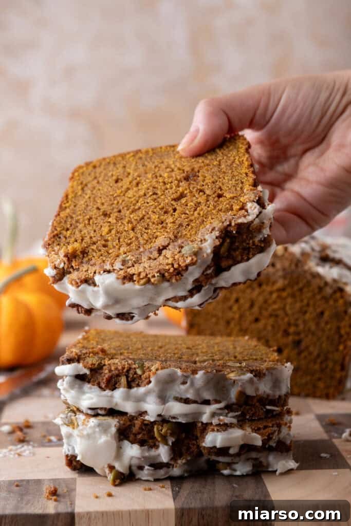Warm Autumn Pumpkin Streusel Loaf 2 streusel pumpkin bread being picked up by a hand