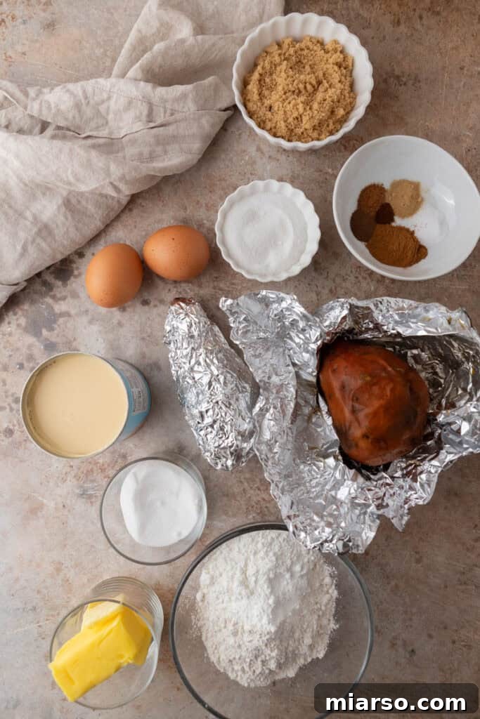 All the fresh ingredients meticulously laid out for making sweet potato pie bars, including cooked sweet potatoes, a variety of spices, flour, and softened butter.