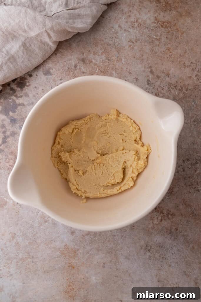 Softened unsalted butter added to the dry ingredients for the shortbread crust, ready for mixing.