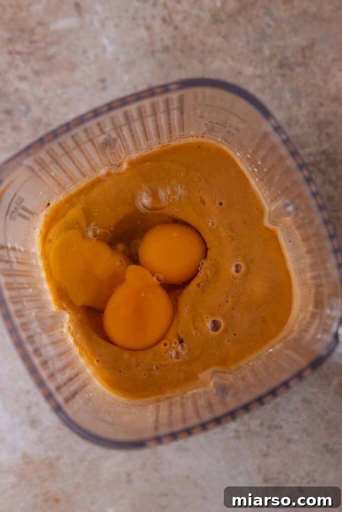 The sweet potato filling ingredients actively blending in a food processor, transforming into a smooth, consistent mixture.