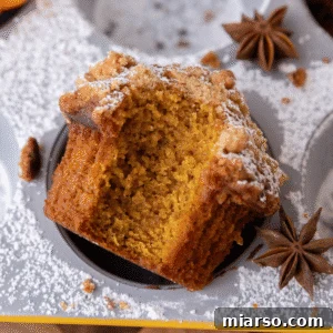Copycat Panera Bread pumpkin muffin with a bite taken out, showing fluffy, moist crumb and sweet streusel topping