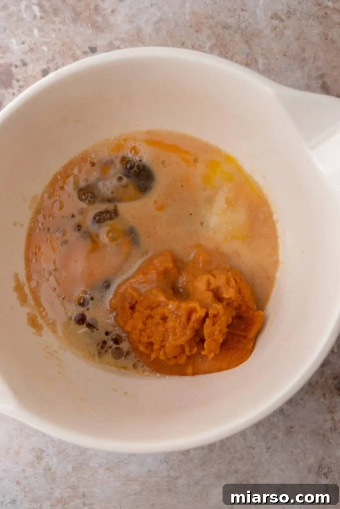 Soft Bakery Pumpkin Muffins Inspired by Panera 8 wet ingredients in a bowl